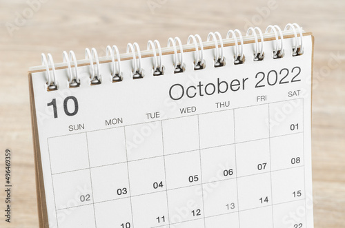 October 2022 desk calendar on wooden background.