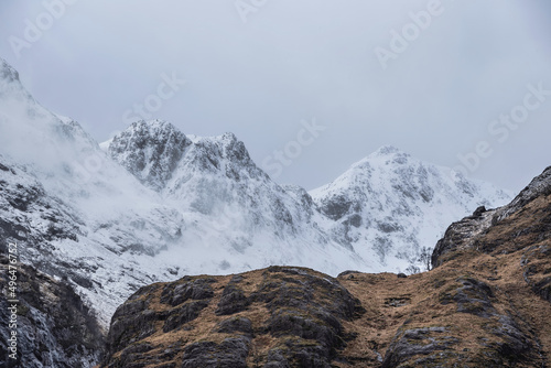 Stunning Winter landscape image of snowcapped Three Sisters mountain range in Glencoe Scottish Highands with dramatic sky photo