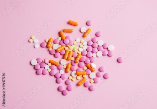 Top view colorful pills on pink background.