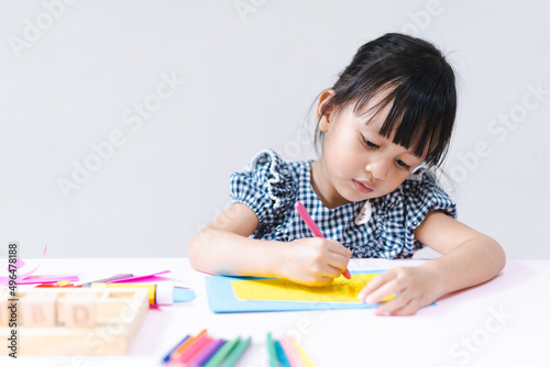 Adorable asian little girl is making do it yourself special gift happy birthday card for her father with happy moment, concept STEAM and creativity learning activity for kid development.