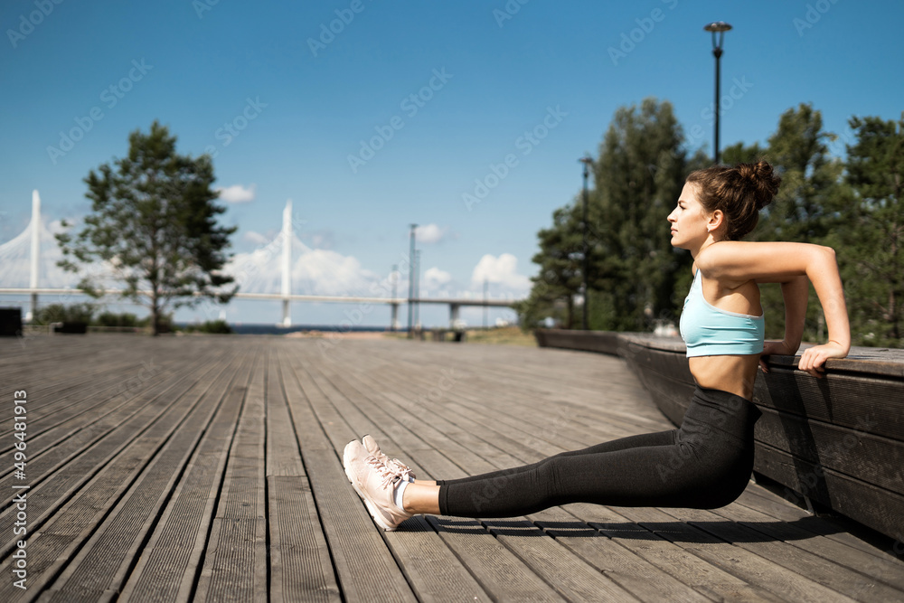 Athletic woman outdoor workout, stretching and body warm-up, sportswear