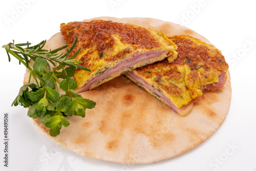 Omelette with herbs stuffed with ham and cheese on top of flatbread isolated on white, clipping path photo