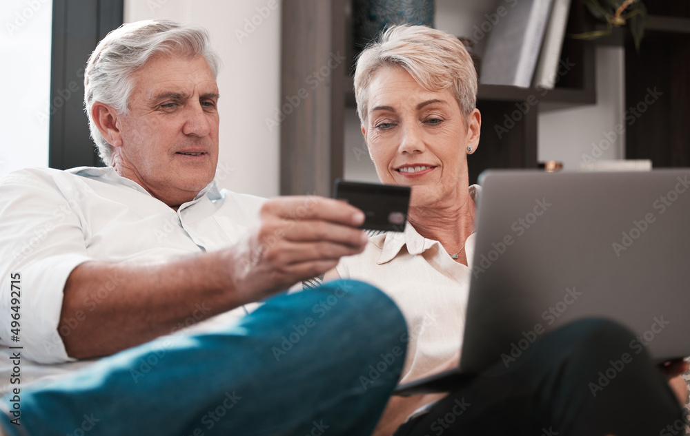 Obraz premium its strange you never knew. Shot of a mature couple using a laptop and paying with a credit card at home together.