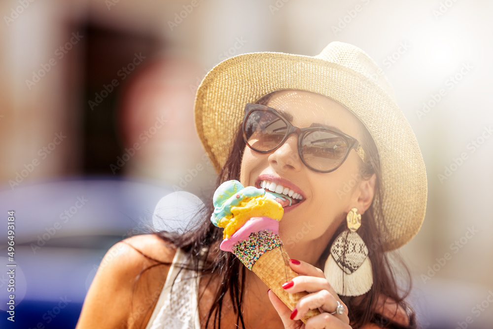 Beautiful happy woman licks ice cream during a hot summer day