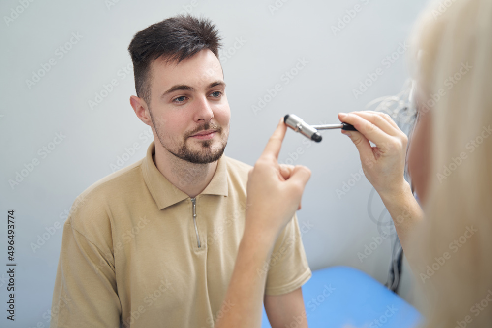 Young calm man during check-up at neurologist Young calm man during check-up at neurologist