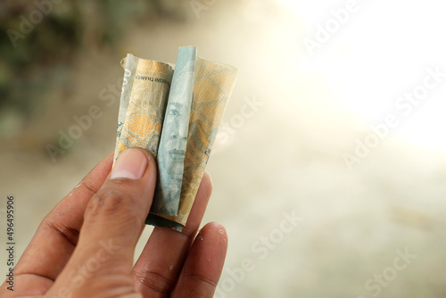 Hand holding rupiah banknote