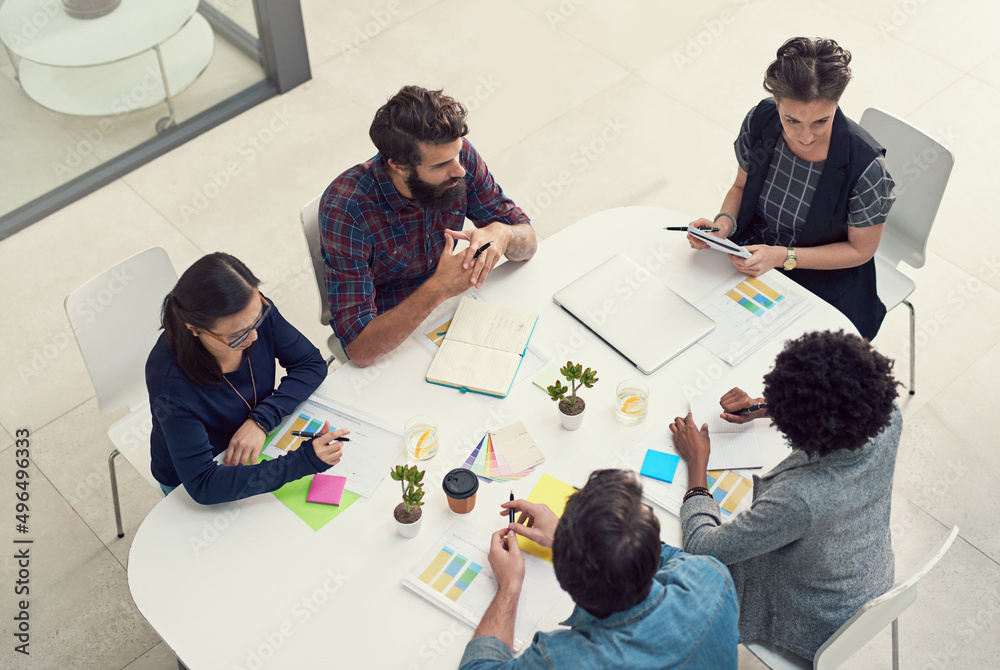Obraz premium Incorporating all the best ideas into their design solutions. Shot of a group of creative businesspeople having a meeting in an office.