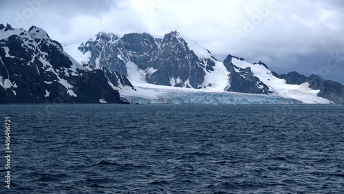 Glacier meeting the Southern Ocean at the base of a rugged mountain in Antarctica