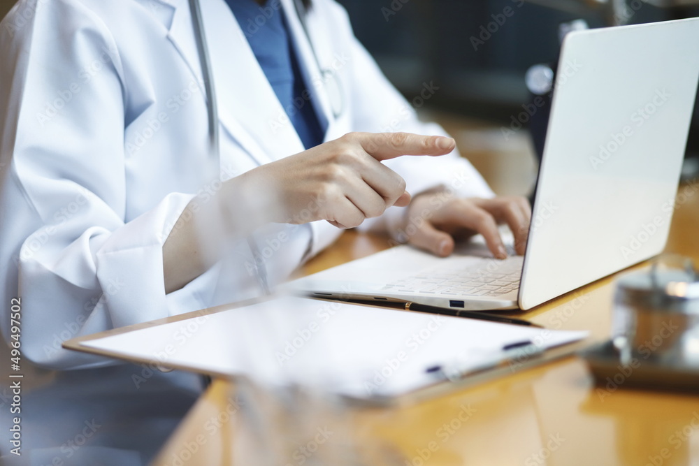 Doctor reviewing medical data with laptop