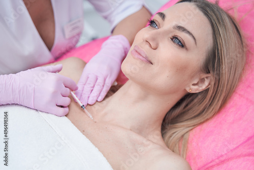 Female patient receiving micro-injection into decolletage area