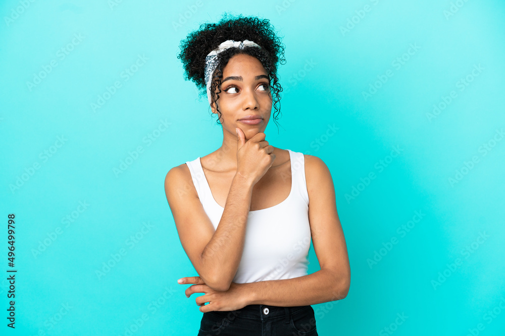 Young latin woman isolated on blue background thinking an idea while looking up Young latin woman isolated on blue background thinking an idea while looking up