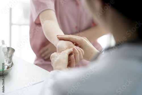Doctor checking patient's hand pain