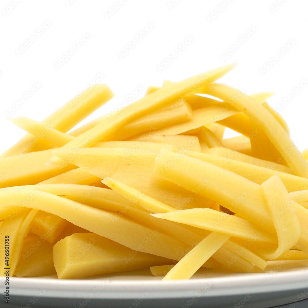 Sliced of bamboo shoots on white dish, isolated on white background. One of the ingredients for Asian cuisines. spot focus