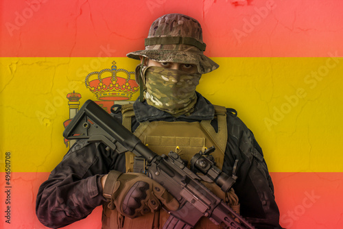 Angry spanish soldier armed with a rifle with spain flag as background behind