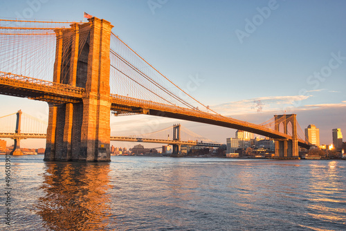 Brooklyn Bridge during sunset in winter. Famous Brooklyn Bridge in orange light from the setting sun. Wonderful clear and crisp picture of New York's bridges on a cold winter day. 