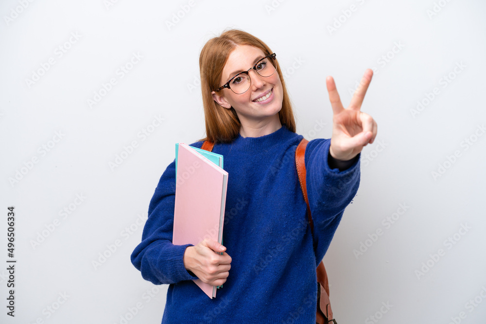Young student redhead woman isolated on white background smiling and showing victory sign Young student redhead woman isolated on white background smiling and showing victory sign