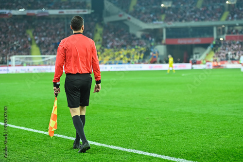 Soccer touchline referee with the flag during match at the football stadium. © Dziurek
