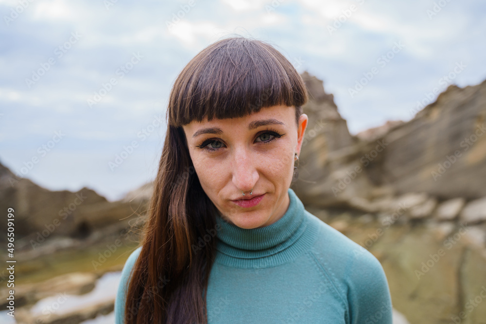 Stylish woman with fringes looking straight ahead by the sea