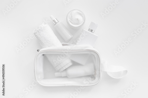 Cosmetic bag with white cosmetic products, top view
