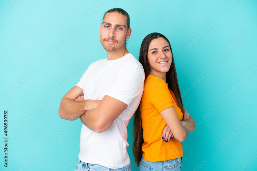 Young caucasian couple isolated on blue background keeping arms crossed Young caucasian couple isolated on blue background keeping arms crossed