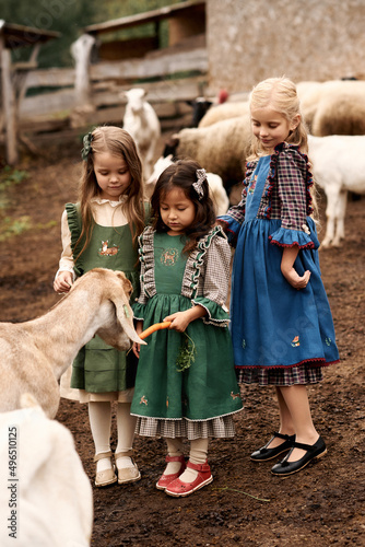 cute children in beautiful green dresses walking on a farm