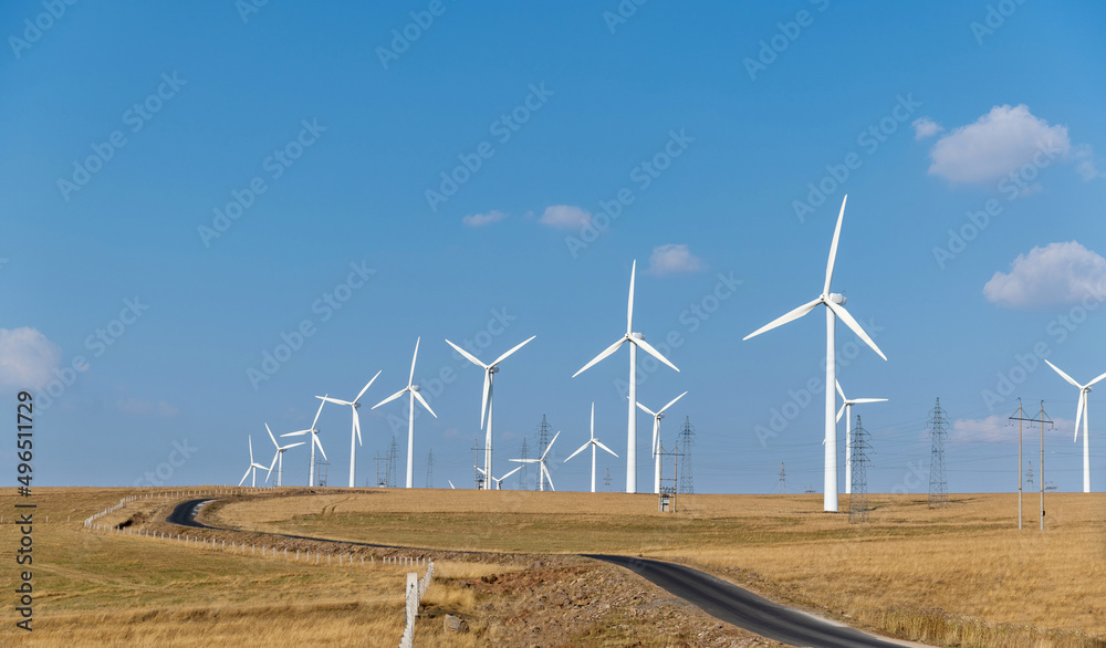 Empty asphalt highway road surrounded by fields with windmills Empty asphalt highway road surrounded by fields with windmills
