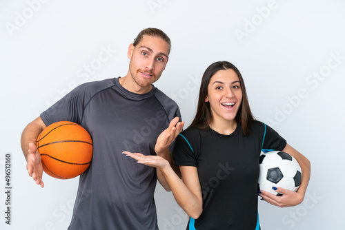 Young caucasian couple playing basketball and football isolated on white background with surprise and shocked facial expression