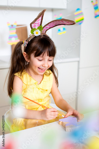 A cute smiling girl of 6 years old paints colorful eggs for the Easter holiday. Christian religion. Ukrainian Orthodoxy
