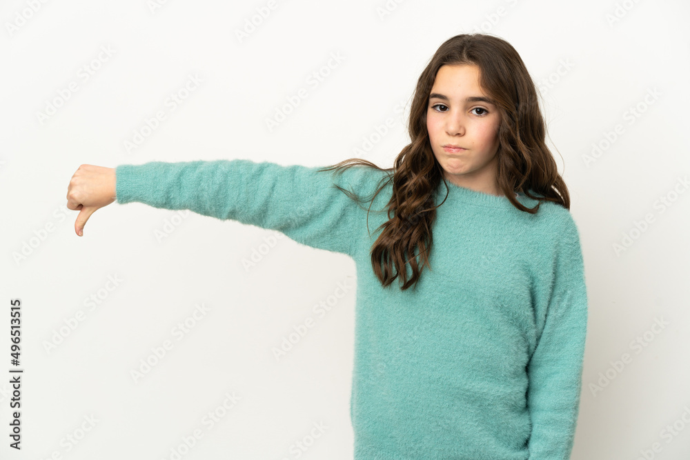 Little caucasian girl isolated on white background showing thumb down with negative expression