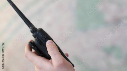 The man's hand uses a portable walkie-talkie on the background of the map. Slow motion video photo