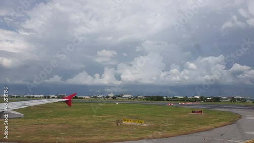Plane landing at airport runway with couldy weather rainy far away landscape photo