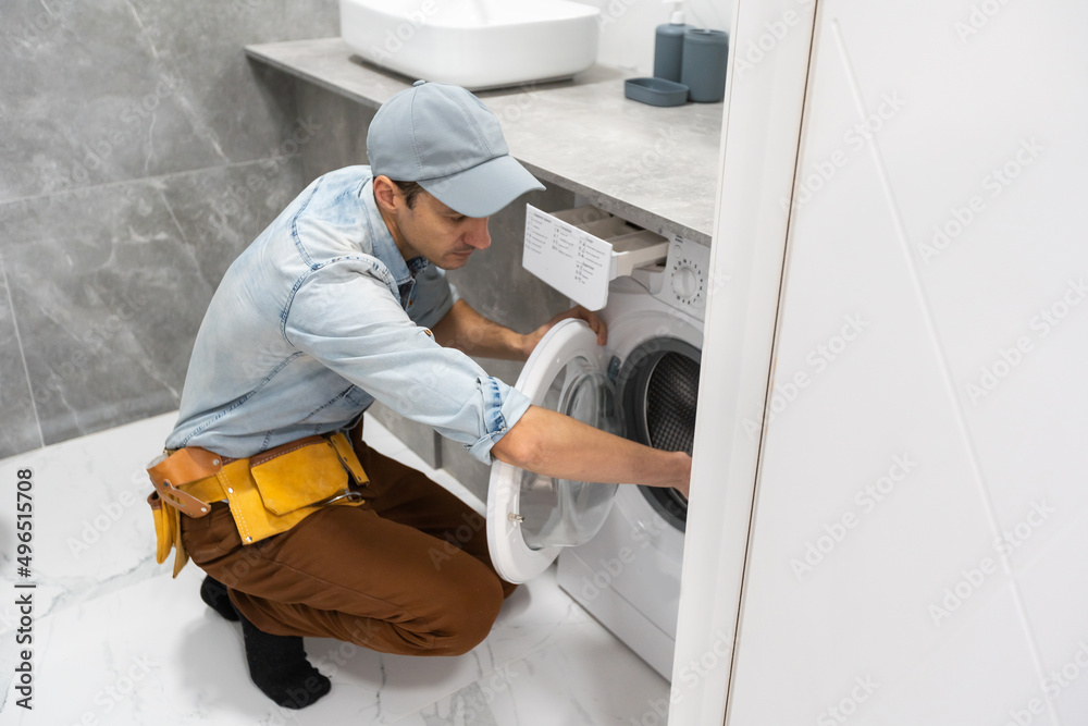 Plumber repairman repairing washing machine Plumber repairman repairing washing machine