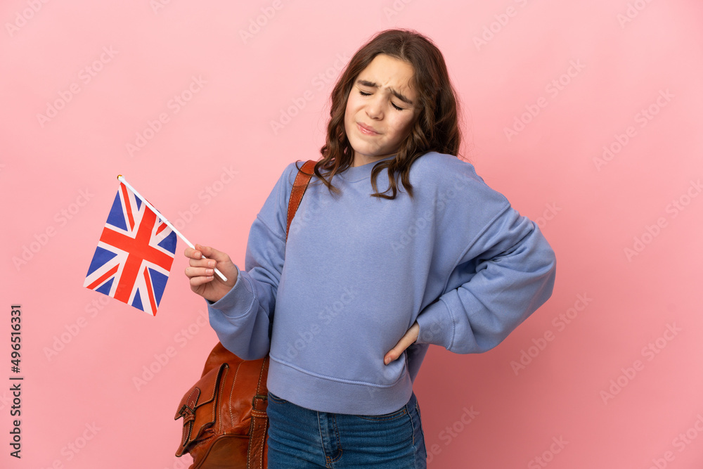 Little girl holding an United Kingdom flag isolated on pink background suffering from backache for having made an effort