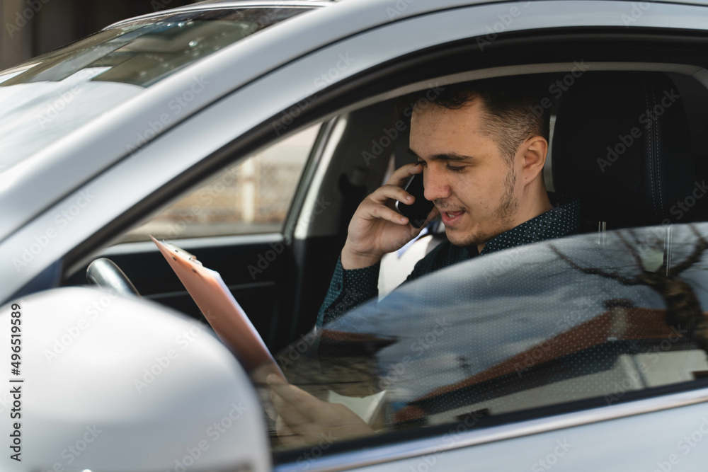 A young businessman arguing business on his phone while in his car A young businessman arguing business on his phone while in his car