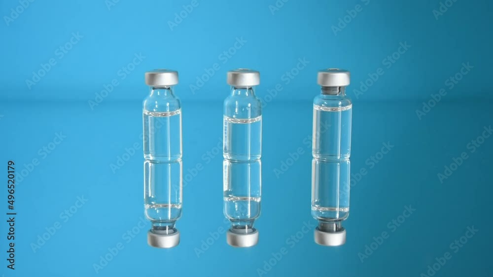 Vaccine bottles and syringe, treatment for COVID-19, influenza or flu, worldwide mass vaccination for coronavirus, global immunization concept with third booster dose. 4K resolution Vaccine bottles and syringe, treatment for COVID-19, influenza or flu, worldwide mass vaccination for coronavirus, global immunization concept with third booster dose. 4K resolution