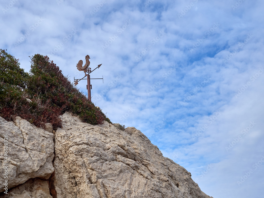 Weather vane on top of a rock in Cala San Vicente, in the north of Majorca, Baleric Islands, Mediterranean, Spain, Europe Weather vane on top of a rock in Cala San Vicente, in the north of Majorca, Baleric Islands, Mediterranean, Spain, Europe