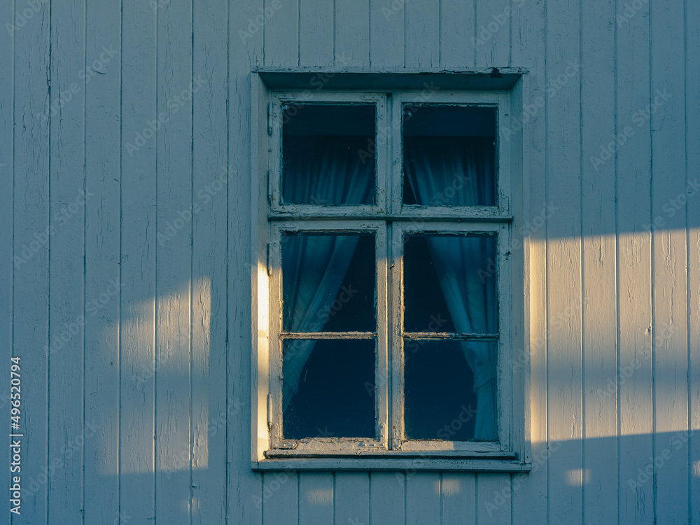 old window of an abandoned farmhouse in the evening light