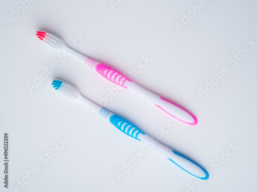 Two toothbrushes. Pink and blue. View from above.