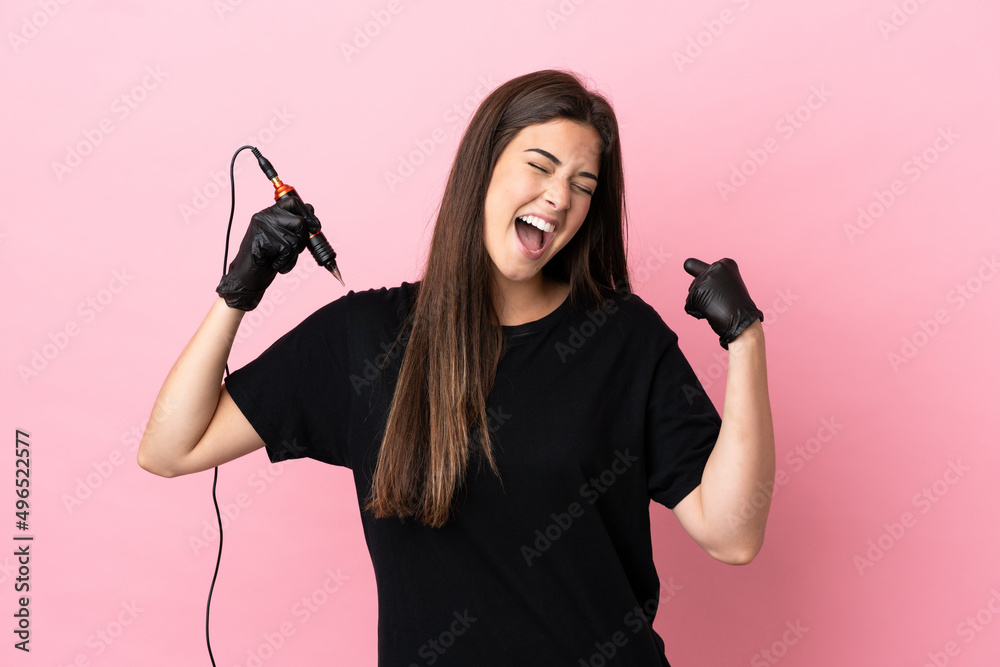 Tattoo artist woman isolated on pink background celebrating a victory