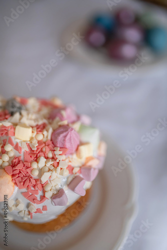 Festive Easter cakes with white icing and sugar decor on a table decorated in spring style