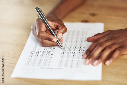 Taking a test. Shot of a person filling in an answer sheet for a test.