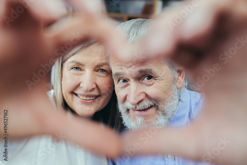 Cuadro en lienzo Affectionate happy old senior couple grandparents make heart shape hand gesture