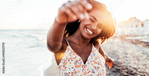 Pretty african woman having fun at the beach - Happy female enjoying vacation by the seaside - Body care, wellness, travel and mental health concept