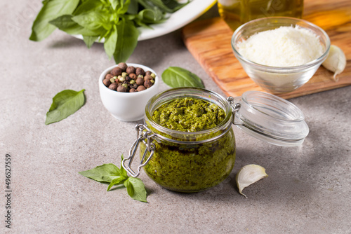 Basil pesto sauce in a jar. Ingredients for cooking, cheese, parmesan, garlic, olive oil. 
