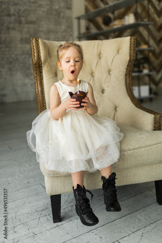 Obraz na płótnie little girl celebrates her birthday. blows out the candle on the cake w salonie