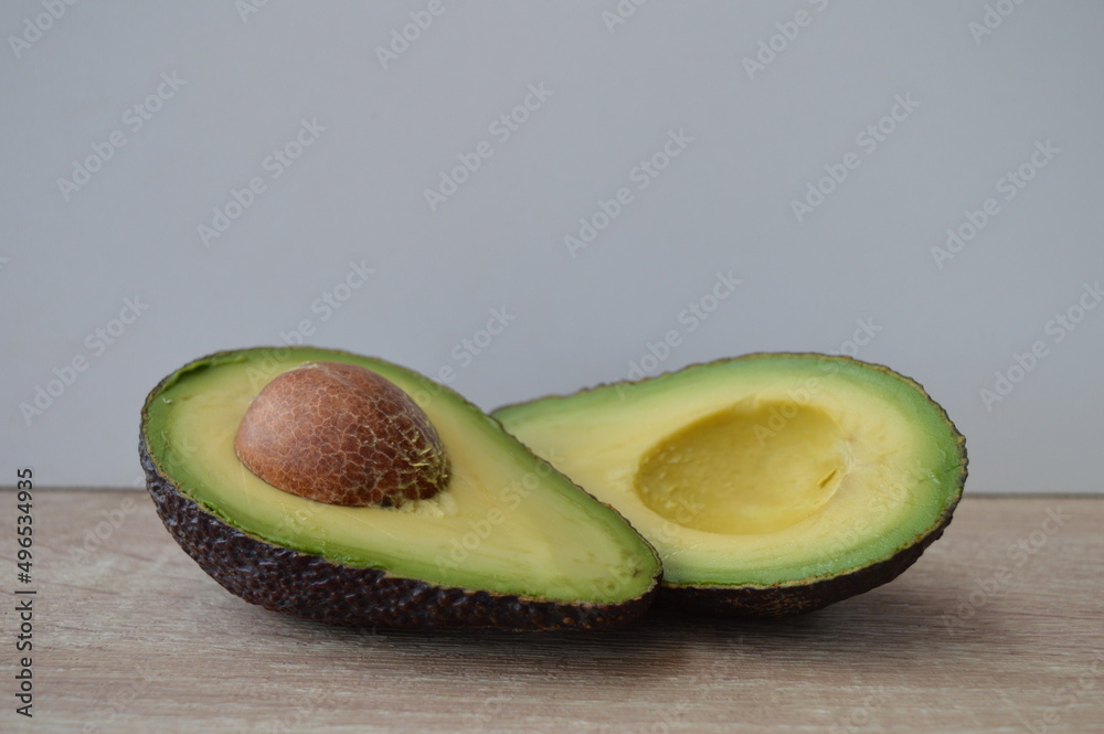 Sliced avocado on a wooden kitchen work table. Exotic fruits full of healthy nutrients