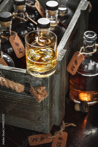 Fototapeta Naklejka Na Ścianę i Meble -  Bourbon with ice in a glass in the distillery.