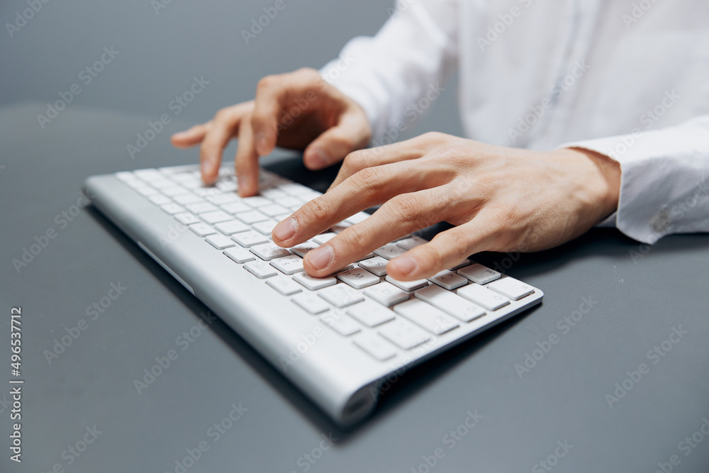 man in a white shirt keyboard work official office Gray background man in a white shirt keyboard work official office Gray background