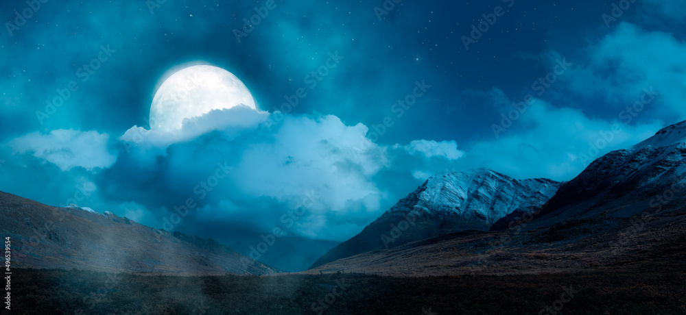 Magical Night Scene with Full Moon in cloudy sky. Mountain Landscape from Yukon