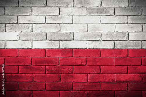 Flaga polski namalowana na ceglanym murze. The Polish flag painted on a brick wall.